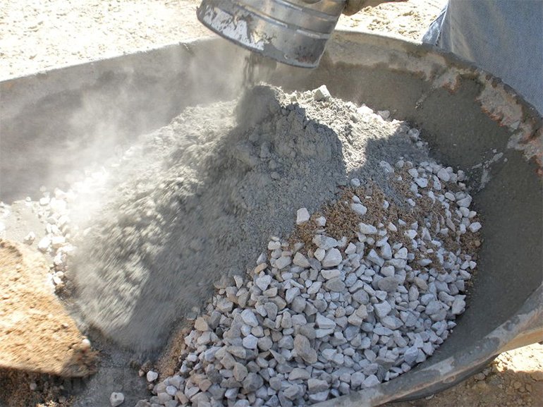 Misturando a mistura de concreto com a adição de pedra britada