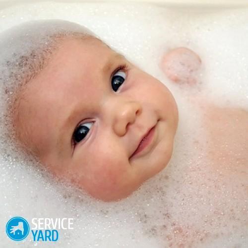 Un bambino in una vasca da bagno con schiuma di sapone.